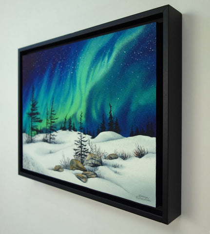Dancing With the Stars by Karen Richardson.
Framed painting of Aurora borealis over a snowy landscape with trees and rocks.