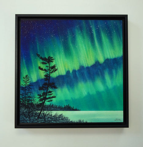 Guardian of the Sky by Karen Richardson.
Framed painting of aurora borealis over a silhouette of trees against a starry night sky.