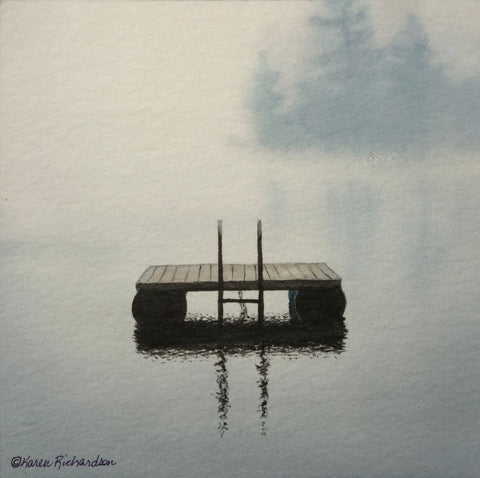 A serene watercolor painting of a small wooden raft floating on calm water, with soft gray-blue mist and trees in the background. Titled Lake Magic by Karen Richardson