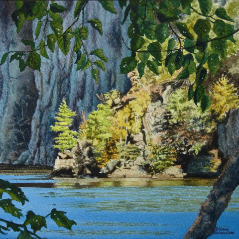 Scenic landscape with trees, rocks, and a blue lake. Titled Mazinaw Moment by Karen Richardson