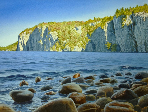 Scenic painting of a lake with rocky shore and cliffs in the background. Titled Mazinaw Morning by Karen Richardson