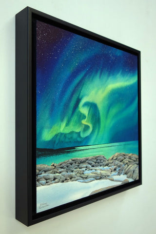 Rhythms of the Night by Karen Richardson.
Framed painting of northern lights over a rocky shoreline with water below.