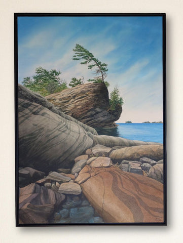 Rocks and windblown trees by Georgian Bay under a clear blue sky, titled Serenity in Stone by Karen Richardson.