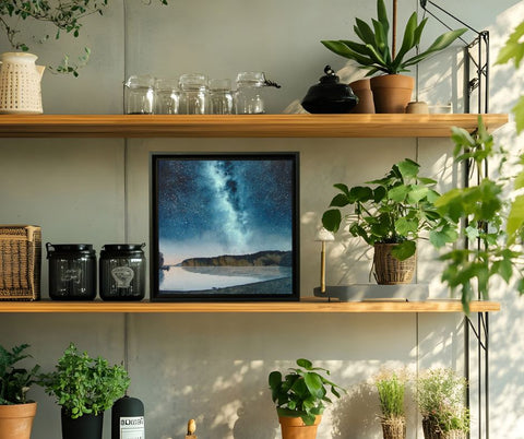 Painting of a starry night sky over a lake with cliffs and trees, titled Mazinaw Midnight, by Karen Richardson displayed in a kitchen setting.