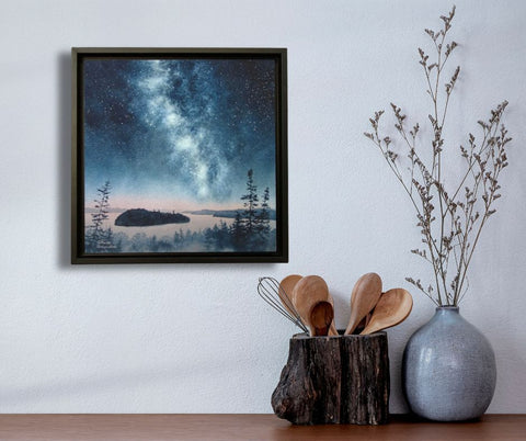 A painting of Lake Superior islands under a starry night sky with the Milky Way, titled Starlit Shores, by Karen Richardson, shown in a kitchen setting.